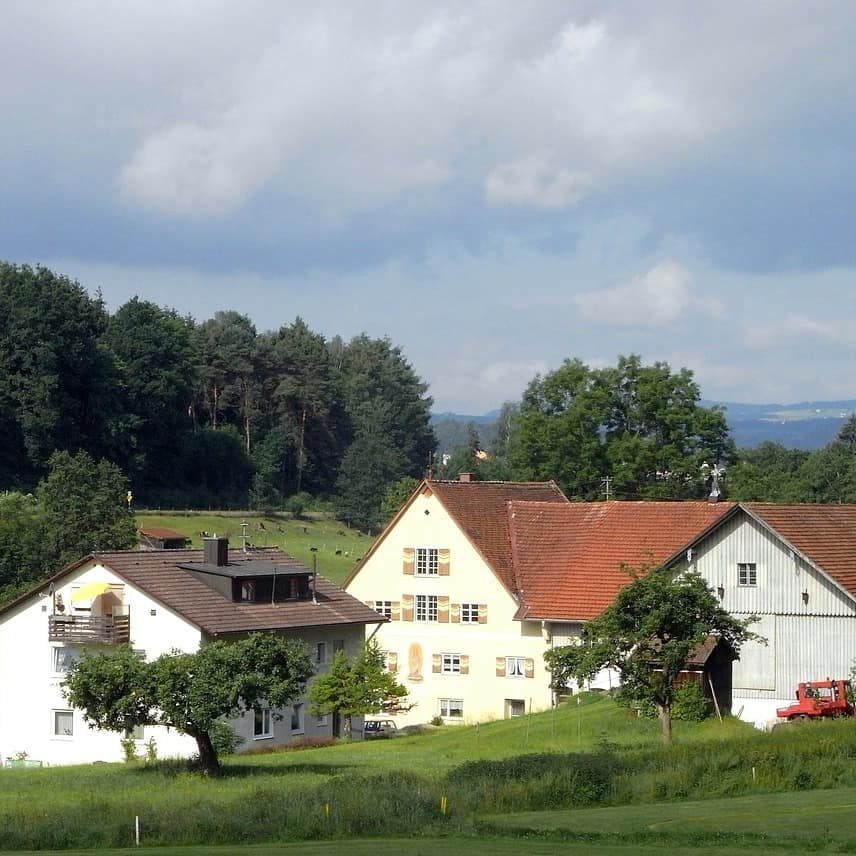 Blick auf einen Bauernhof und die grüne Umgebung in Bayern
