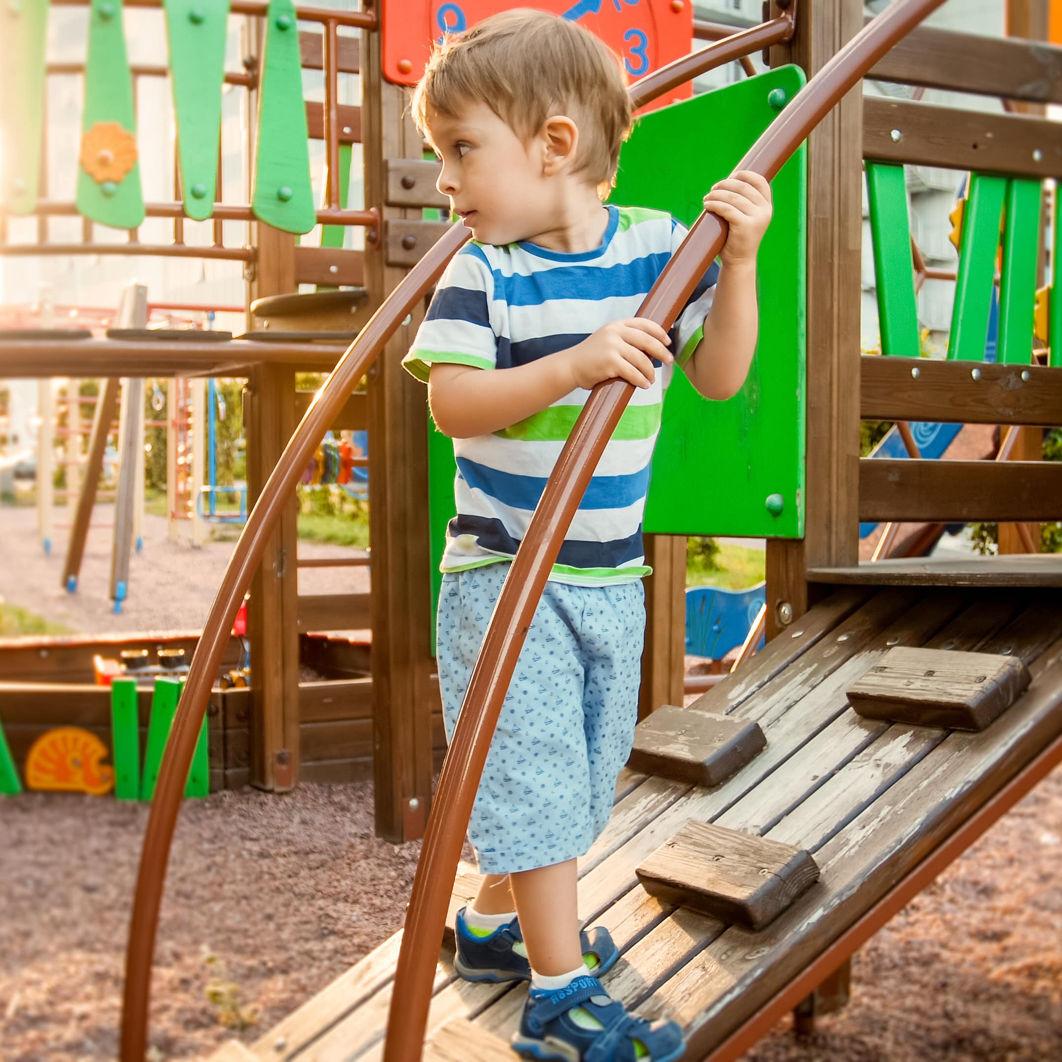 Kleiner Junge auf einem Klettergerüst eines Abenteuerspielplatz.