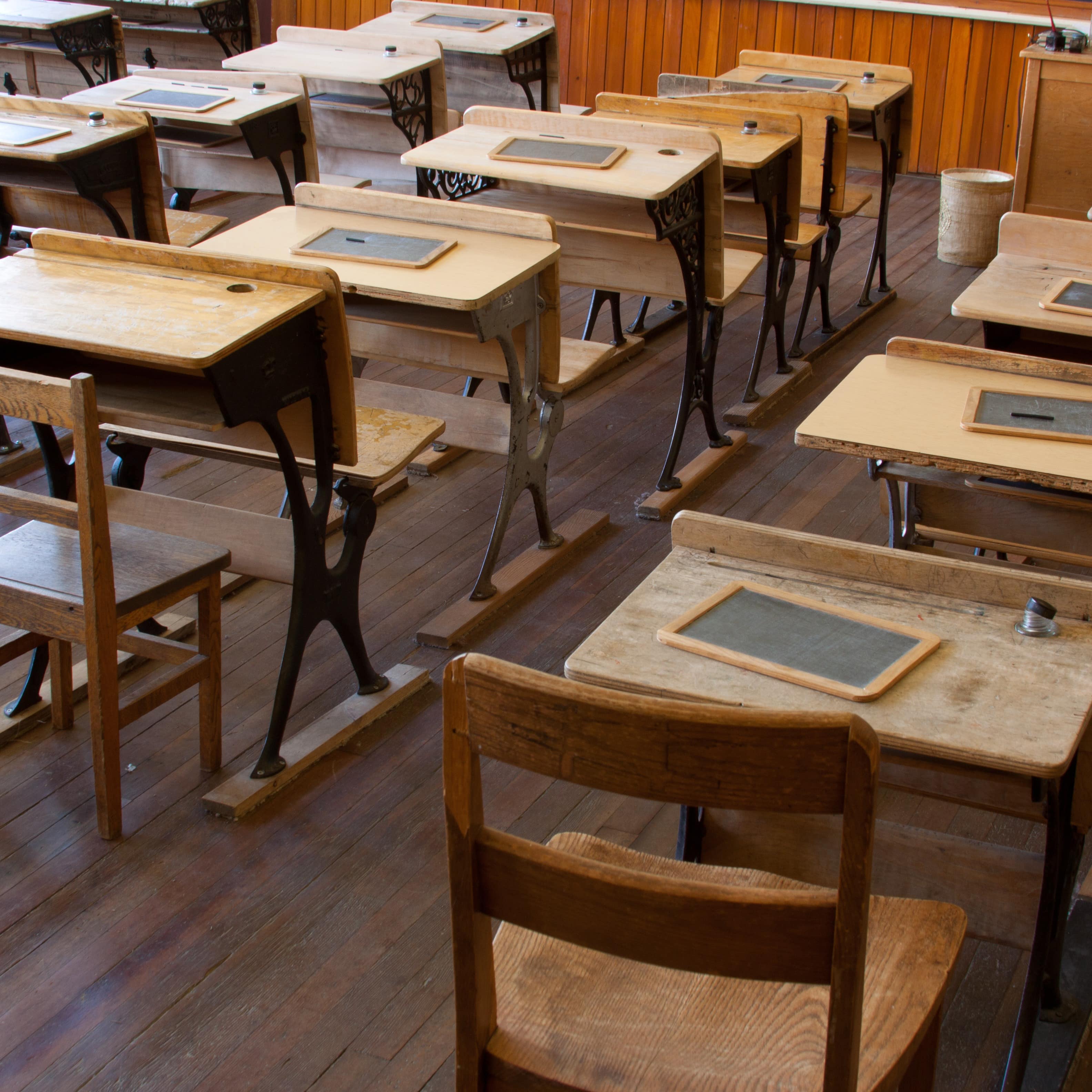 Ein historisches Klassenzimmer, auf jedem Schreibtisch liegt eine kleine Kreidetafel. 