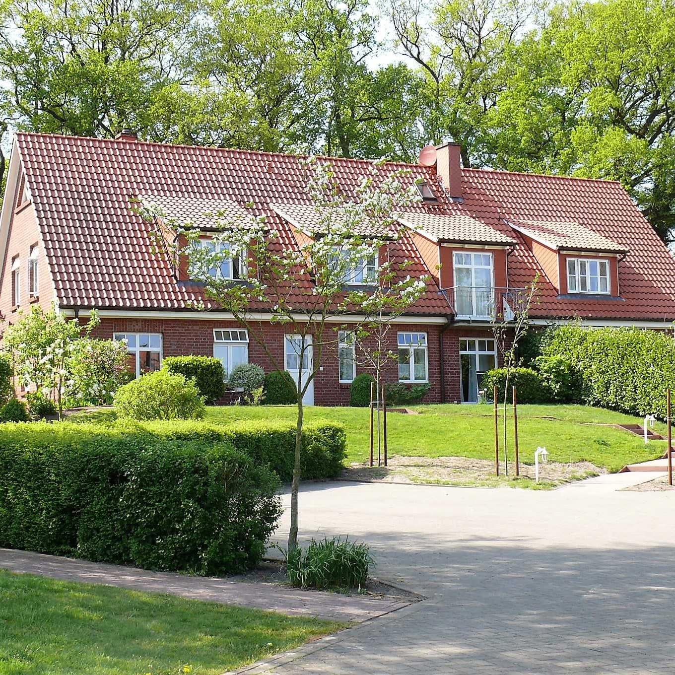 Frontansicht auf ein ländlich gelegenes Haus mit Garten in Jork in dem sich eine barrierefreie Ferienwohnung befindet. 
