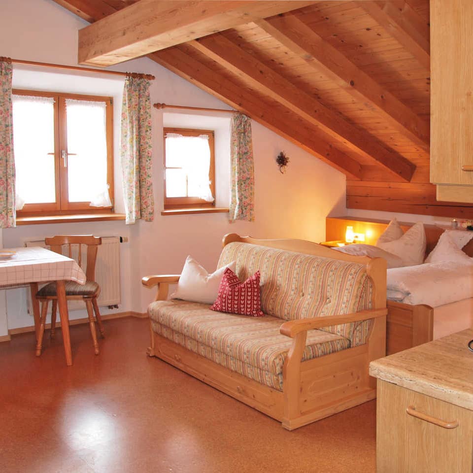 Ferienwohnung am Schliersee in gemütlicher Alpenstube mit holzvertäfelter Decke und rustikalen Holzmöbeln, dazu eine Wohnküche