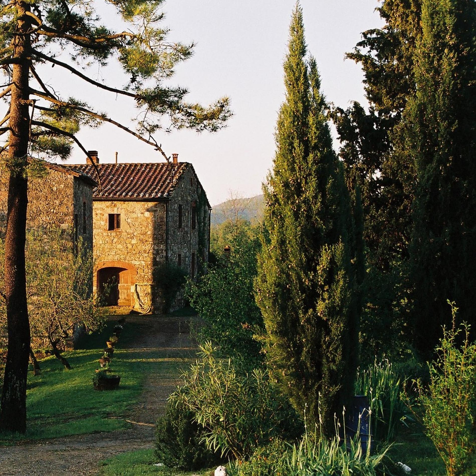 Im Morgenlicht strahlt die Hauswand des aus Naturstein gebauten Bauernhofs Podere Le Querci in der Toskana