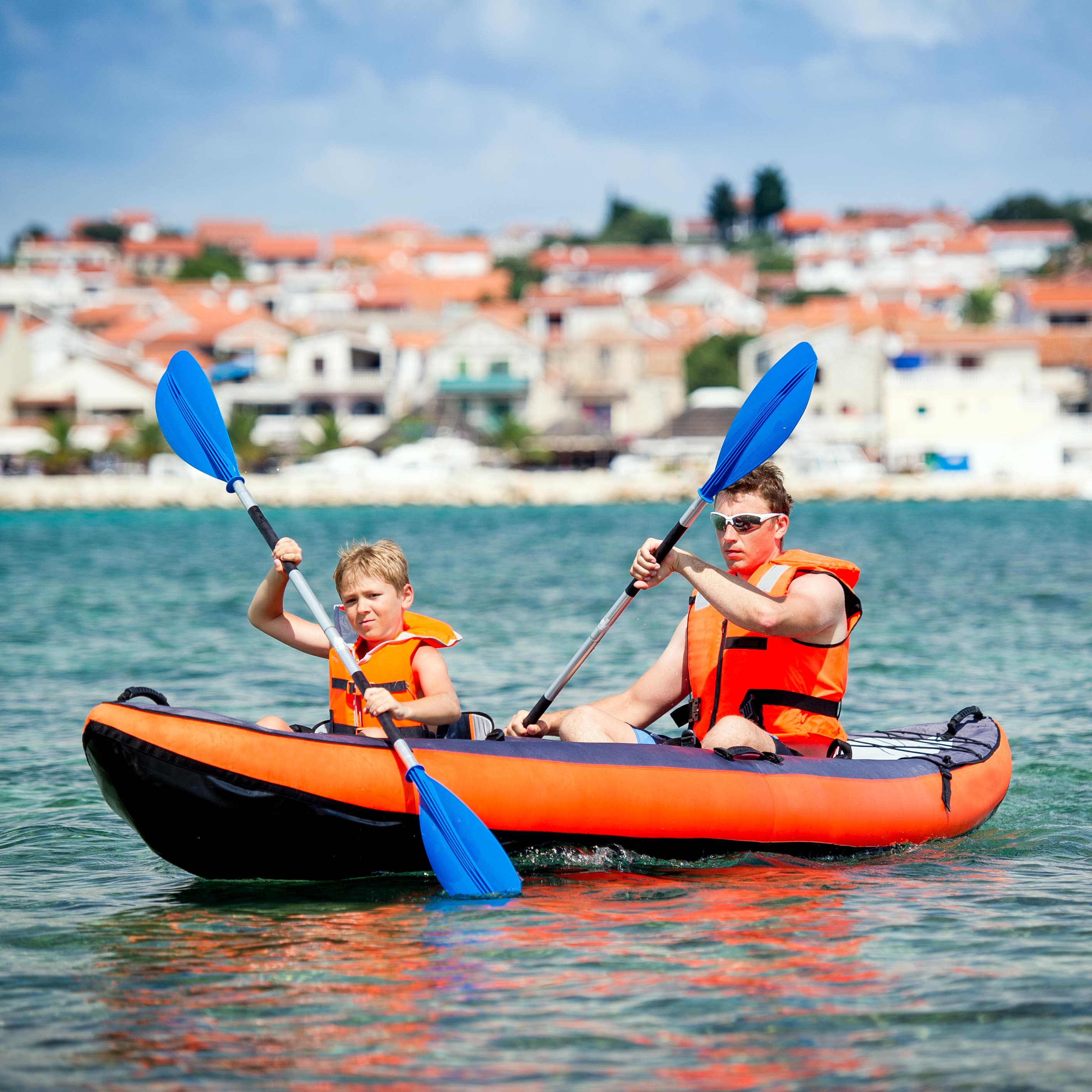 Vater und Sohn mit Schwimmwesten im Kajak irgendwo an die kroatischen Küste.