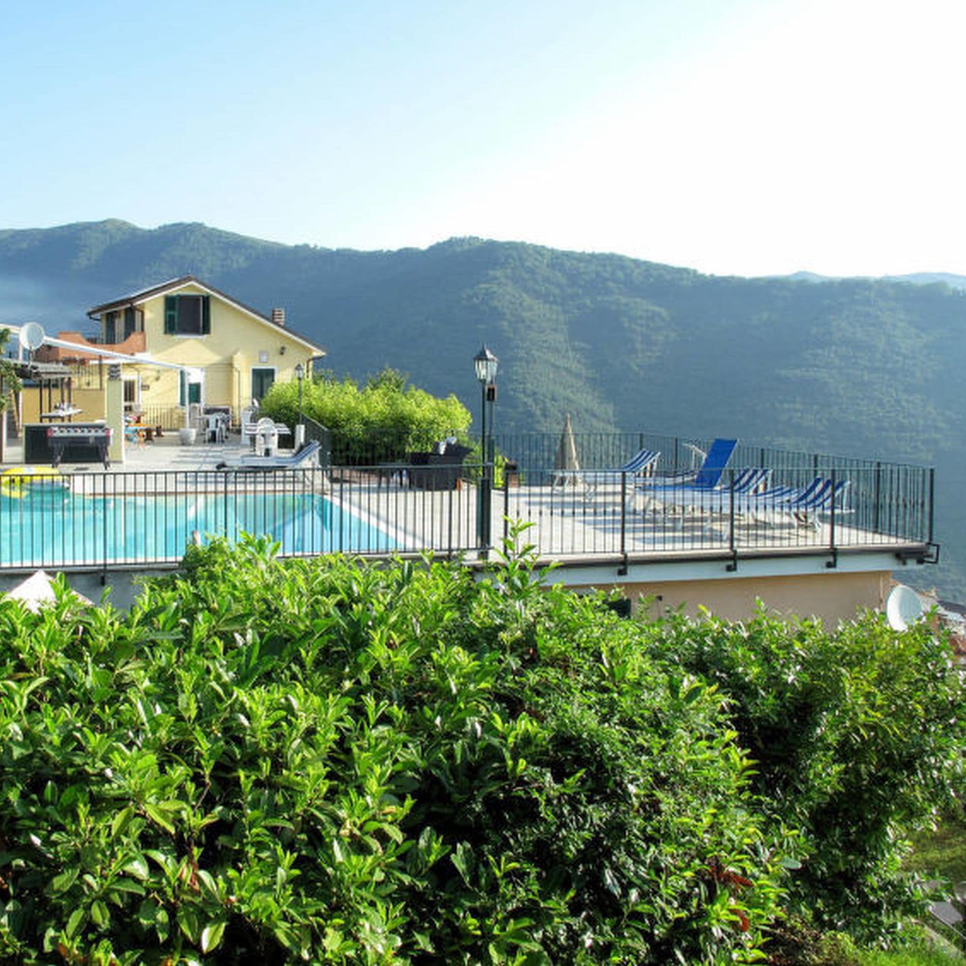 Hoch in den Bergen liegt die Ferienwohnung in Ligurien mit Pool, die einen Ausblick über die bewaldeten Hügel bis zum Meer bietet 