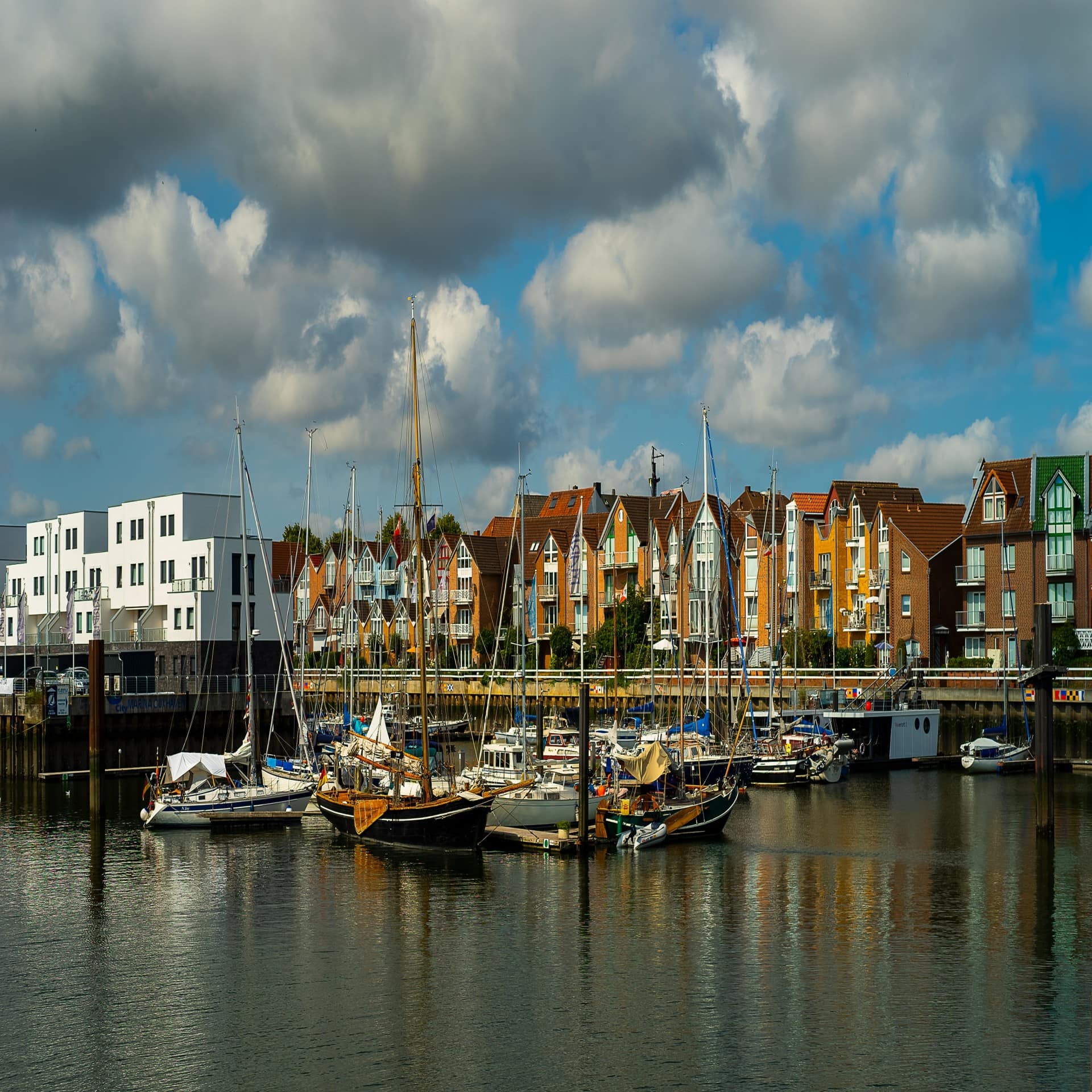 Blick über den Hafen von Cuxhaven mit Booten, dahinter Häuser. 