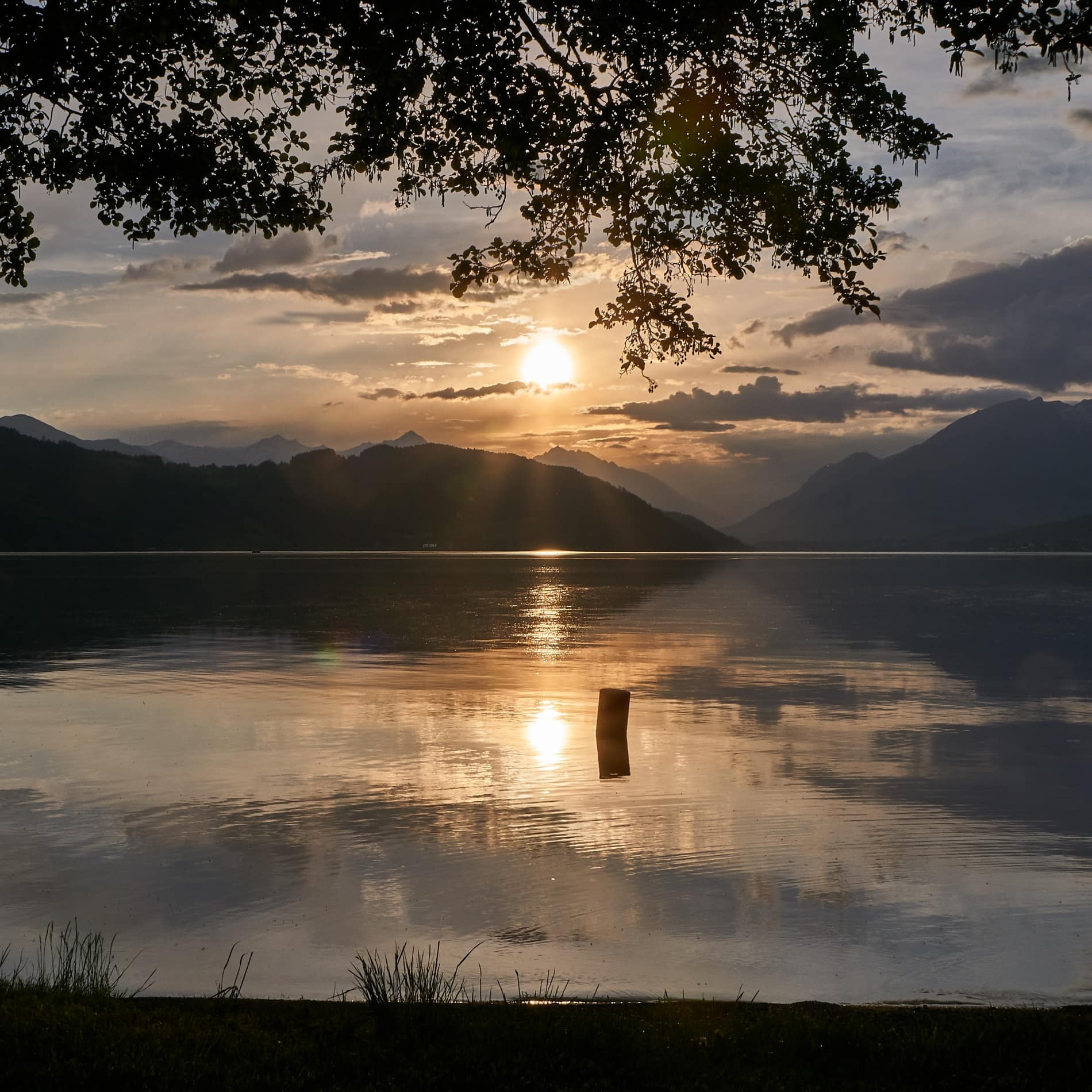 Die untergehende Sonne spiegelt sich im Millstätter See im österreichischen Bundesland Kärnten
