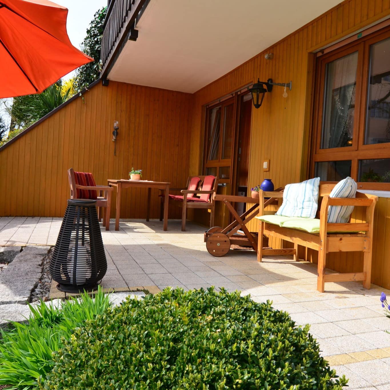 Terrasse einer Ferienwohnung in der Fränkischen Schweiz mit Sitzgelegenheiten und Sonnenschirm