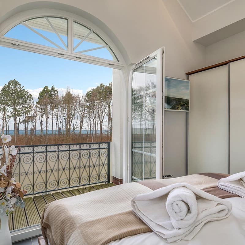 Schlafzimmer mit Balkon mit Meerblick in einer Ferienwohnung auf dem Darß