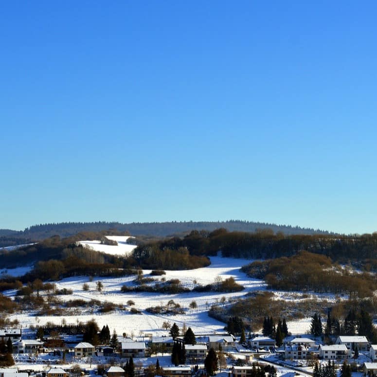 Ein verschneiter Ort in einer Winterlandschaft in der Eifel. 