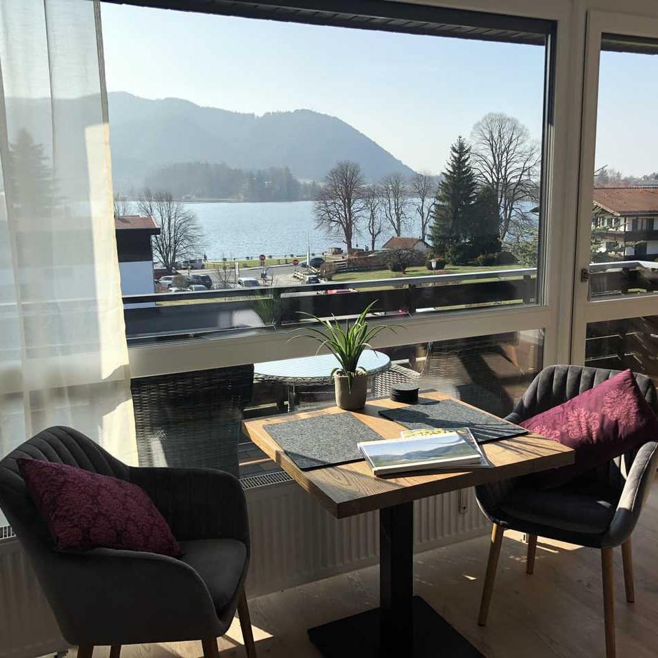 Ferienwohnung am Schliersee mit hellem Wohnzimmer und Balkon, davon Blick über den See