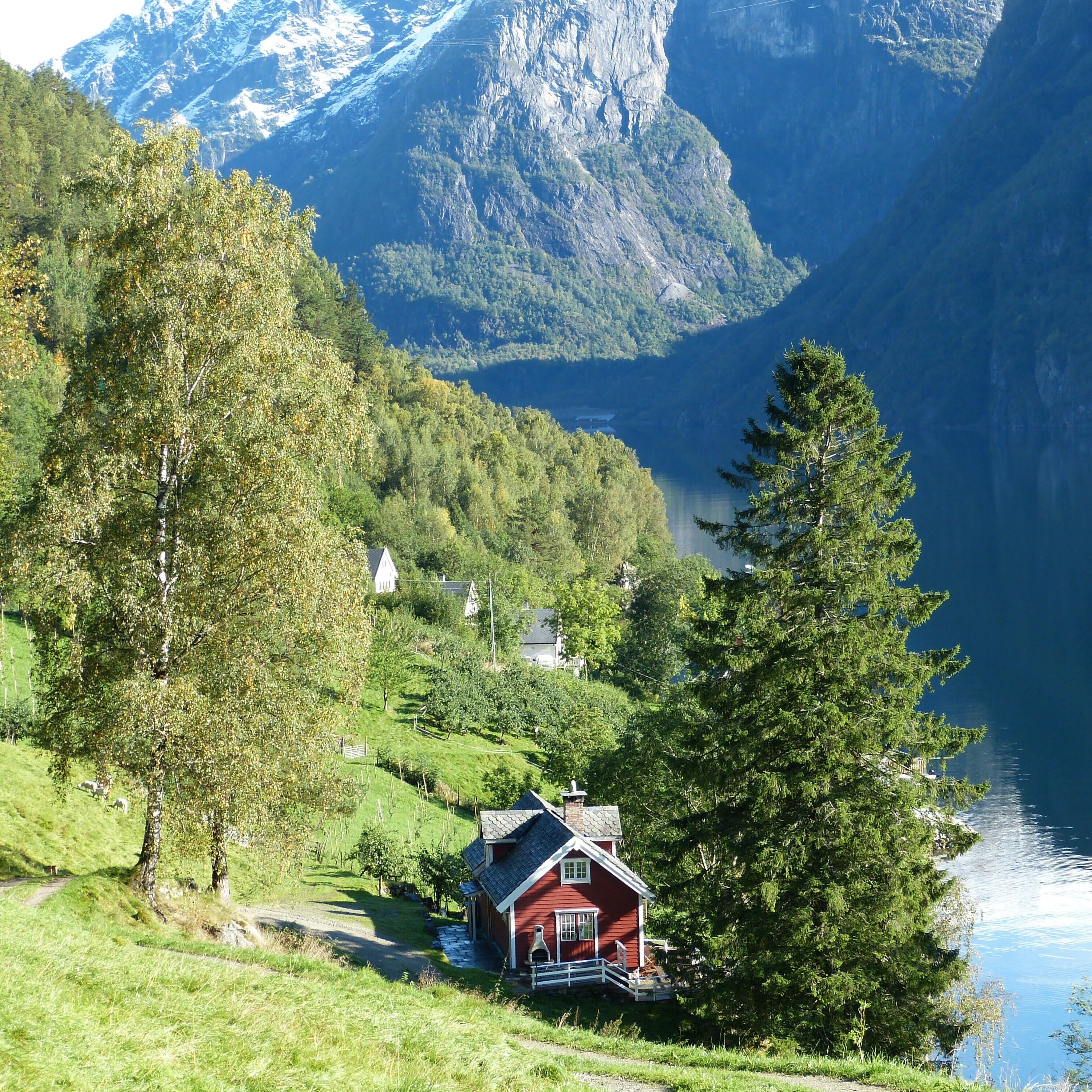 Rotes Holzhaus in atemberaubender Landschaft am Fjord
