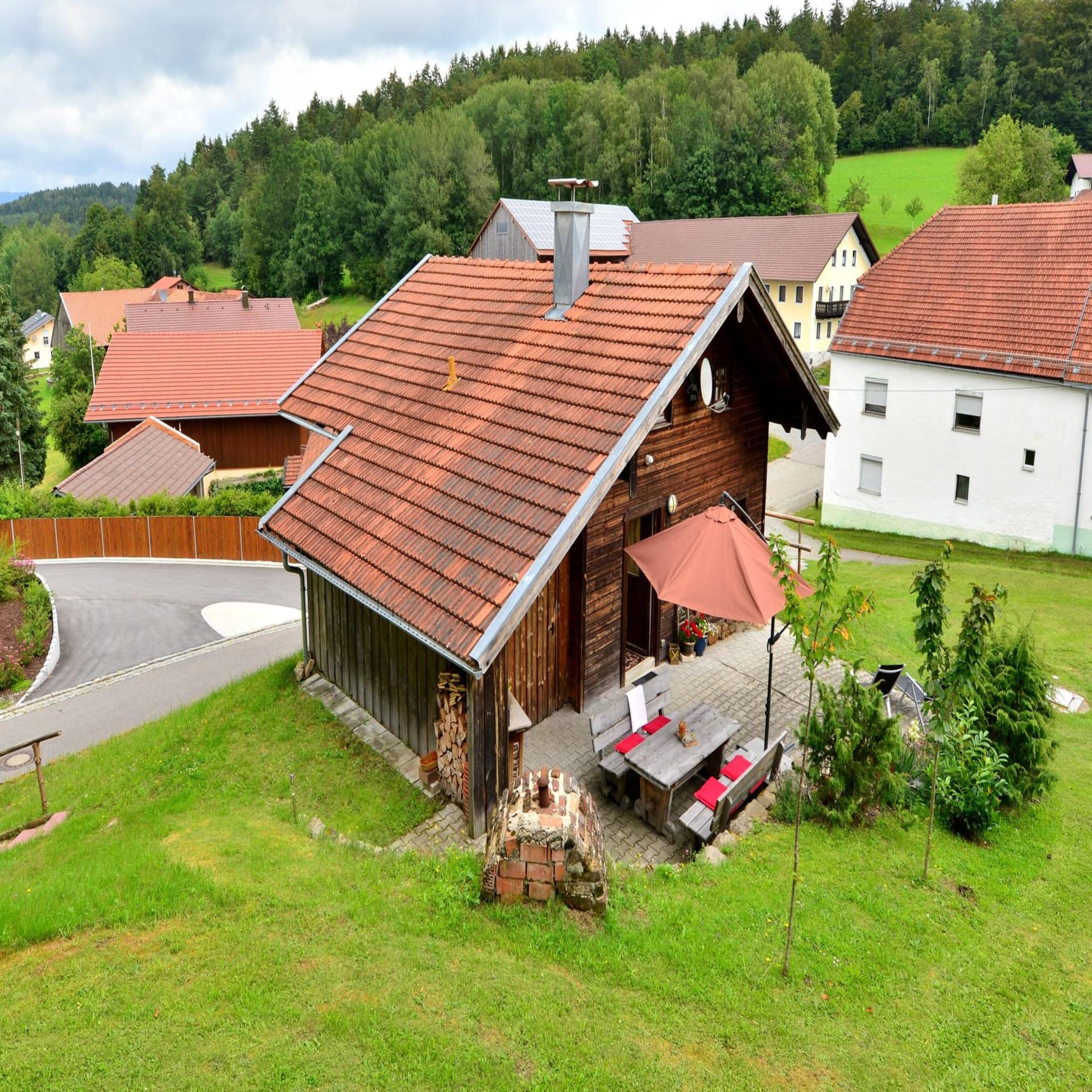 Holzhaus mit Terrasse in einem Dorf im Bayerischen Wald.