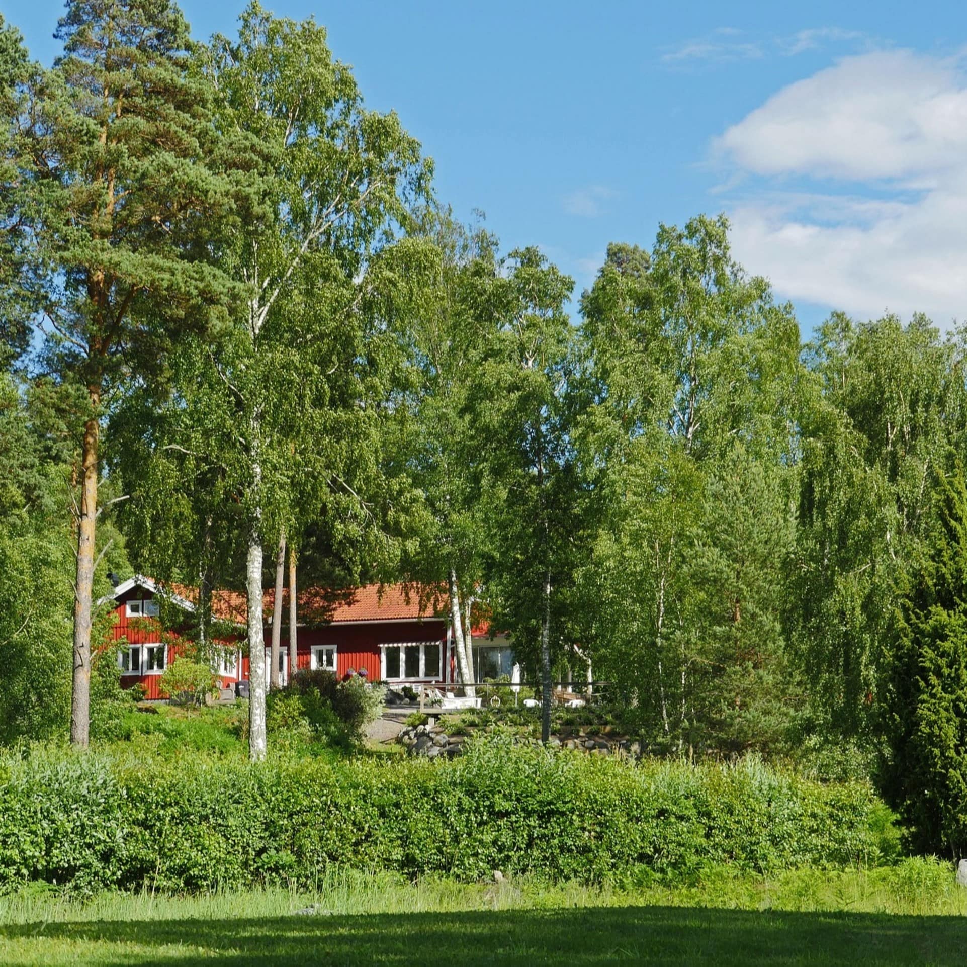 Typisches Schwedenhaus zwischen Bäumen versteckt