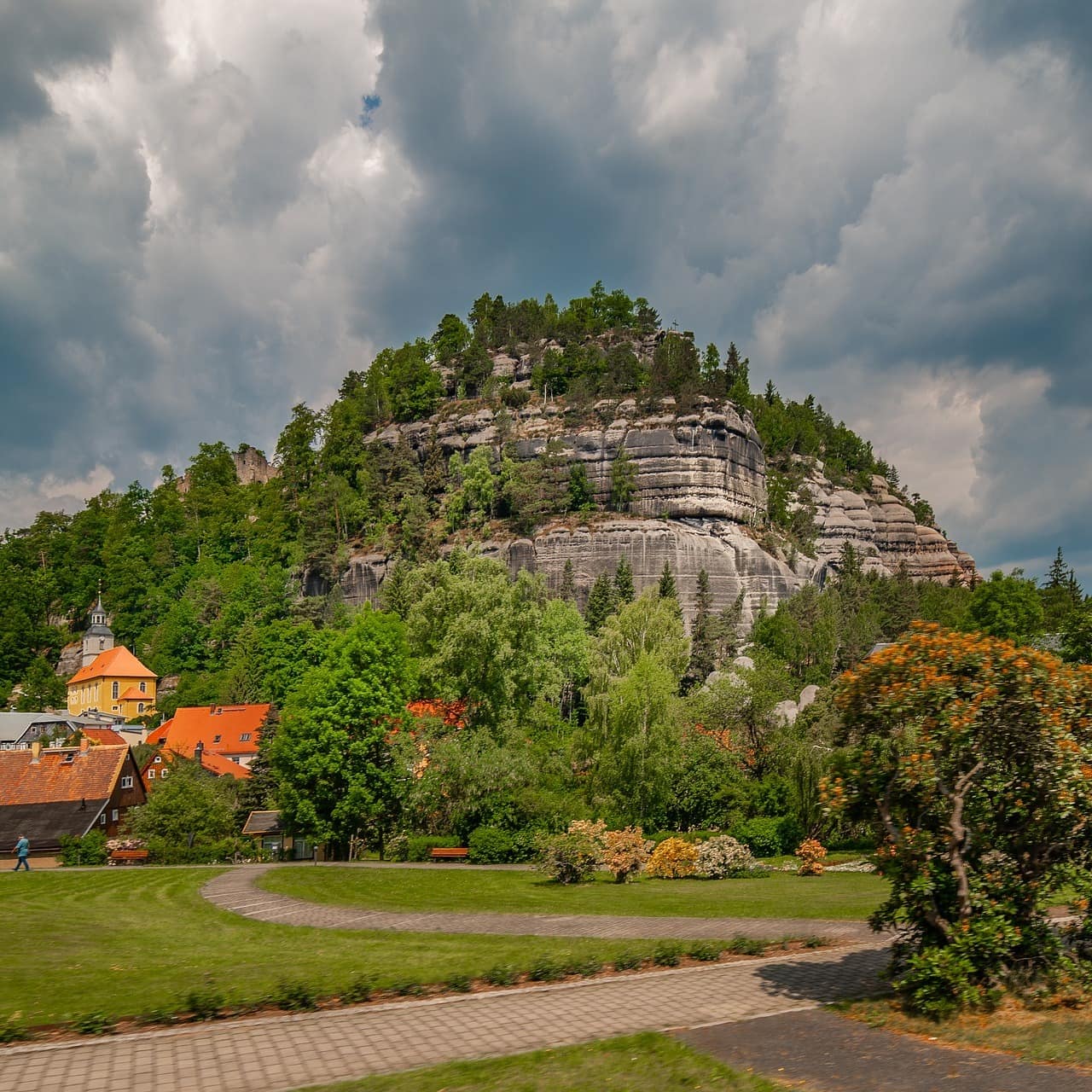 Blick auf einen Park und einen Ort im Erzgebirge mit bewaldetem Berg im Hintergrund