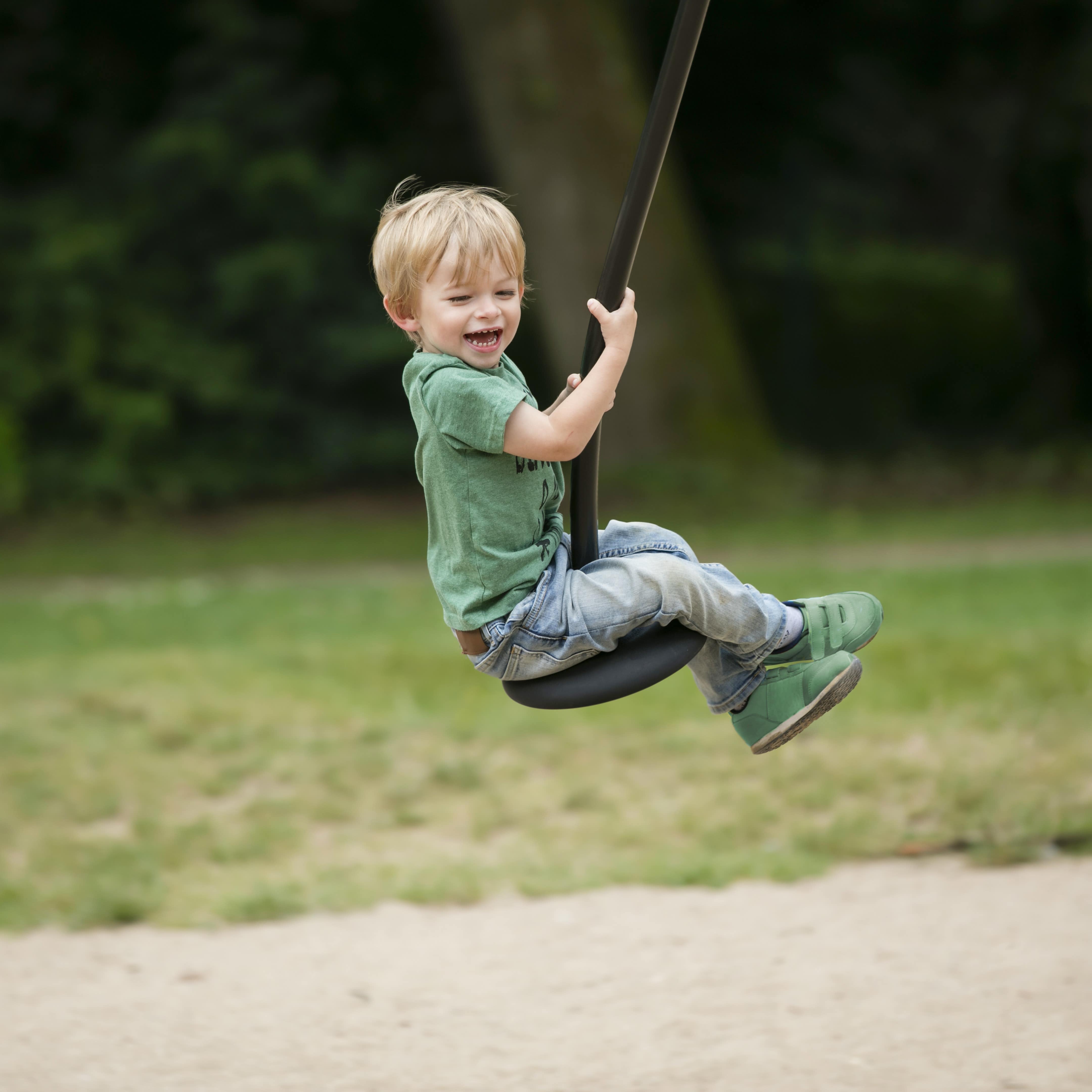 Ein kleiner Junge auf einer Seilbahn auf einem Spielplatz.