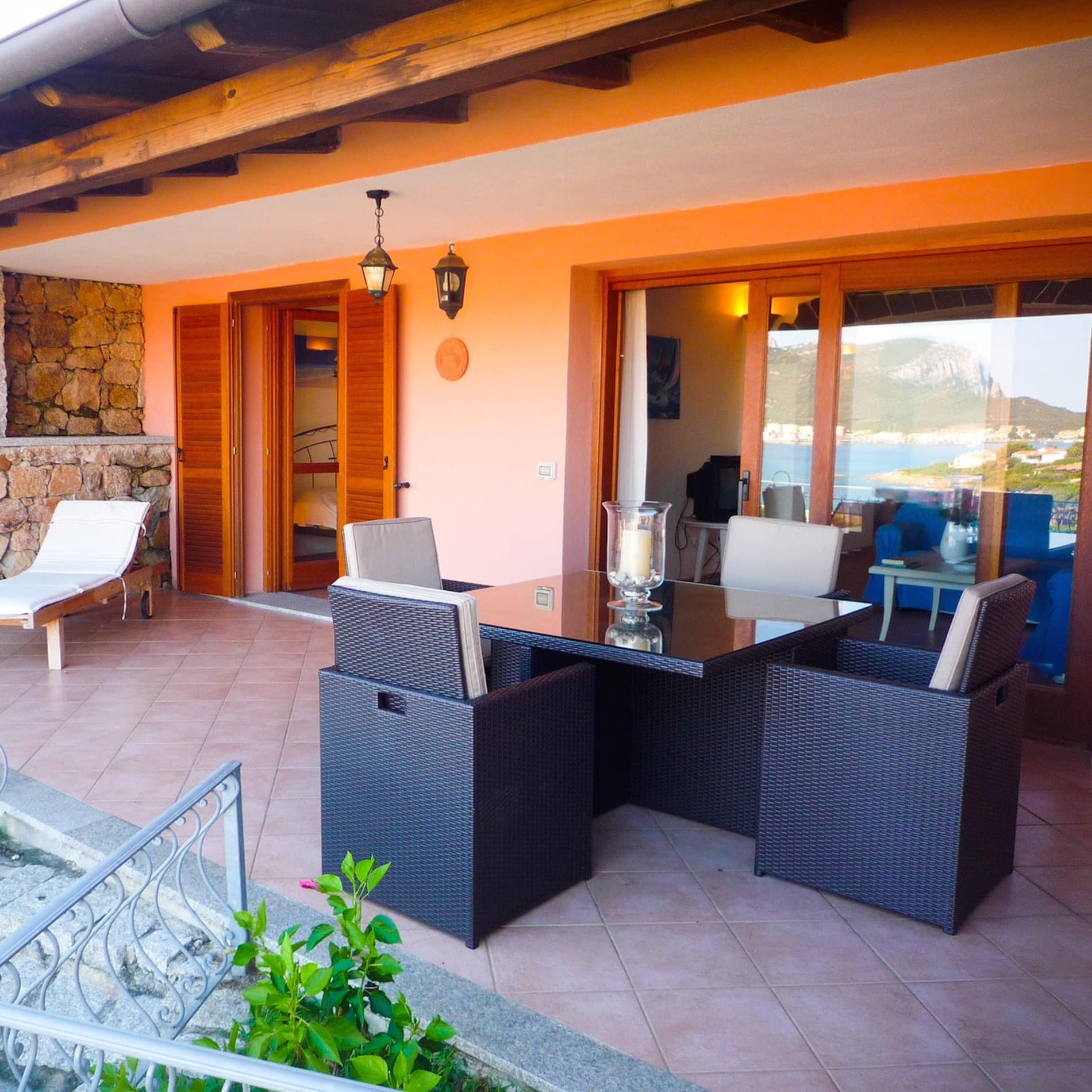 Im Fenster der Ferienwohnung in Golfo Aranci spiegelt sich der herrliche Ausblick auf den Golf und die Gebirgskuppe auf der Halbinsel gegenüber