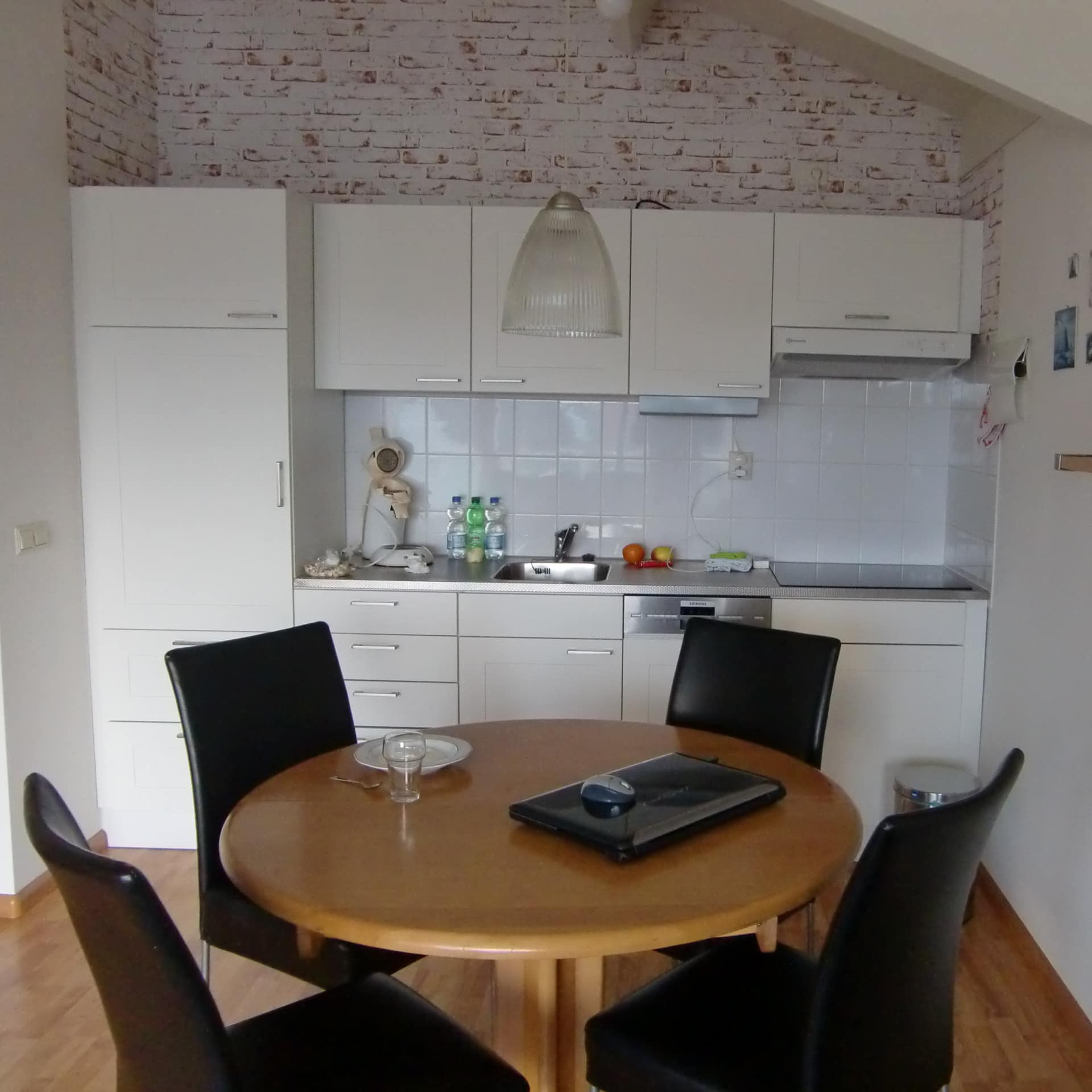 helle Ferienwohnung in den Niederlanden mit großer Küche, darin ein Esstisch und vier Stühle