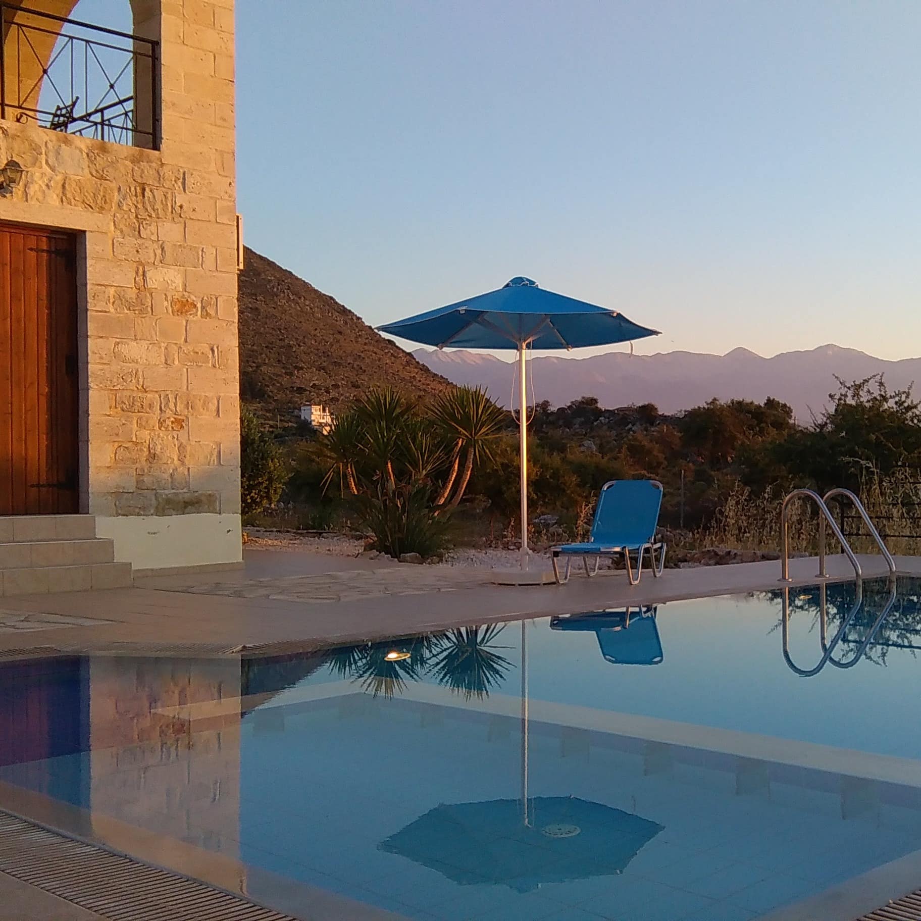 Blick auf den Pool eines Ferienhauses auf Kreta mit Garten