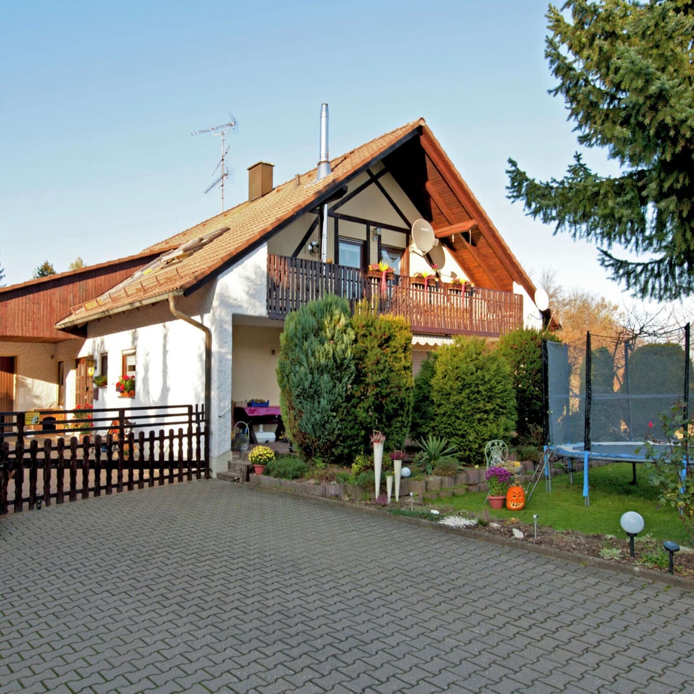 Blick auf ein freistehendes Haus mit Ferienwohnungen in der Fränkischen Schweiz, im Garten steht ein Trampolin