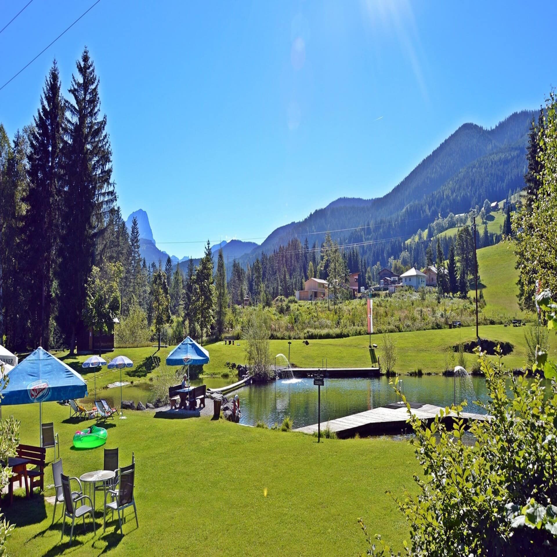 Ein Waldbad mit großer Liegewiese, Sitzgelegenheiten und Sonnenschirmen. 