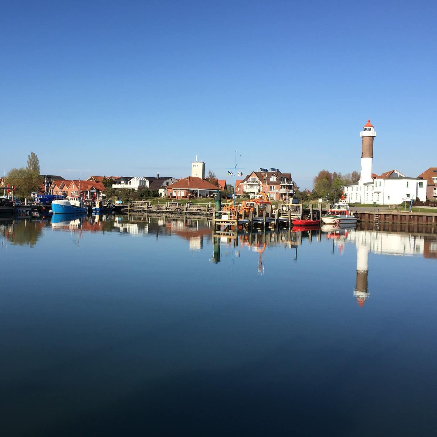 Blick über das Wasser auf den kleinen Hafen von Timmendorf, Häuser sind im Hintergrund zu sehen