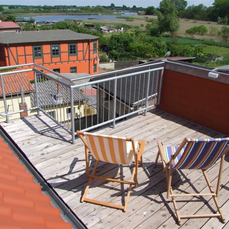 Dachterrasse mit Sonnenstühlen und Seeblick einer Ferienwohnung an der mecklenburgischen Seenplatte