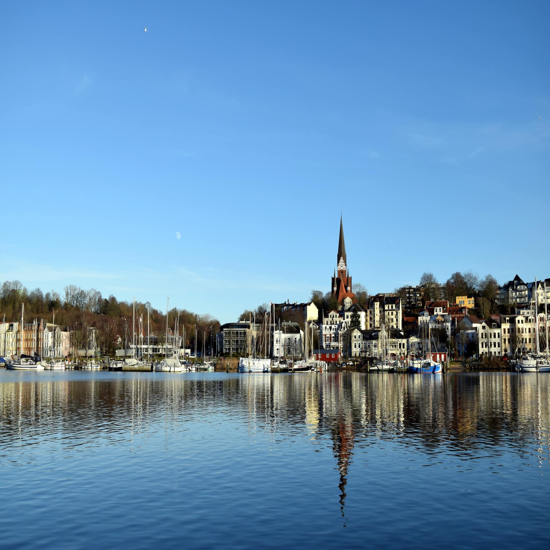 Blick über das Wasser auf den Hafen und die Stadt Flensburg.