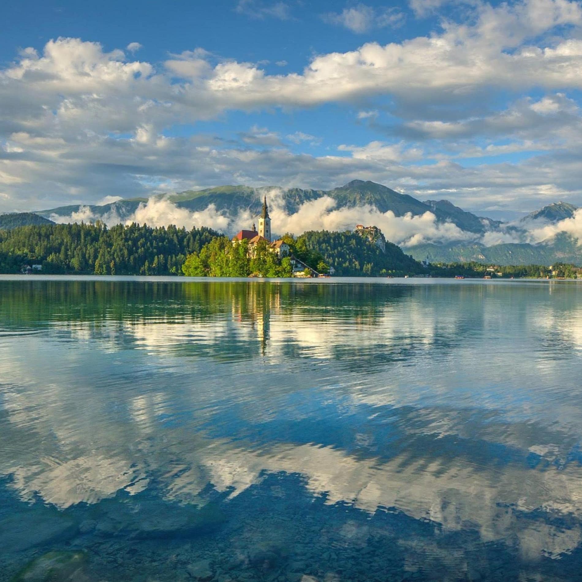 Eine Kirche spiegelt sich im Faaker See in Kärnten, Österreich