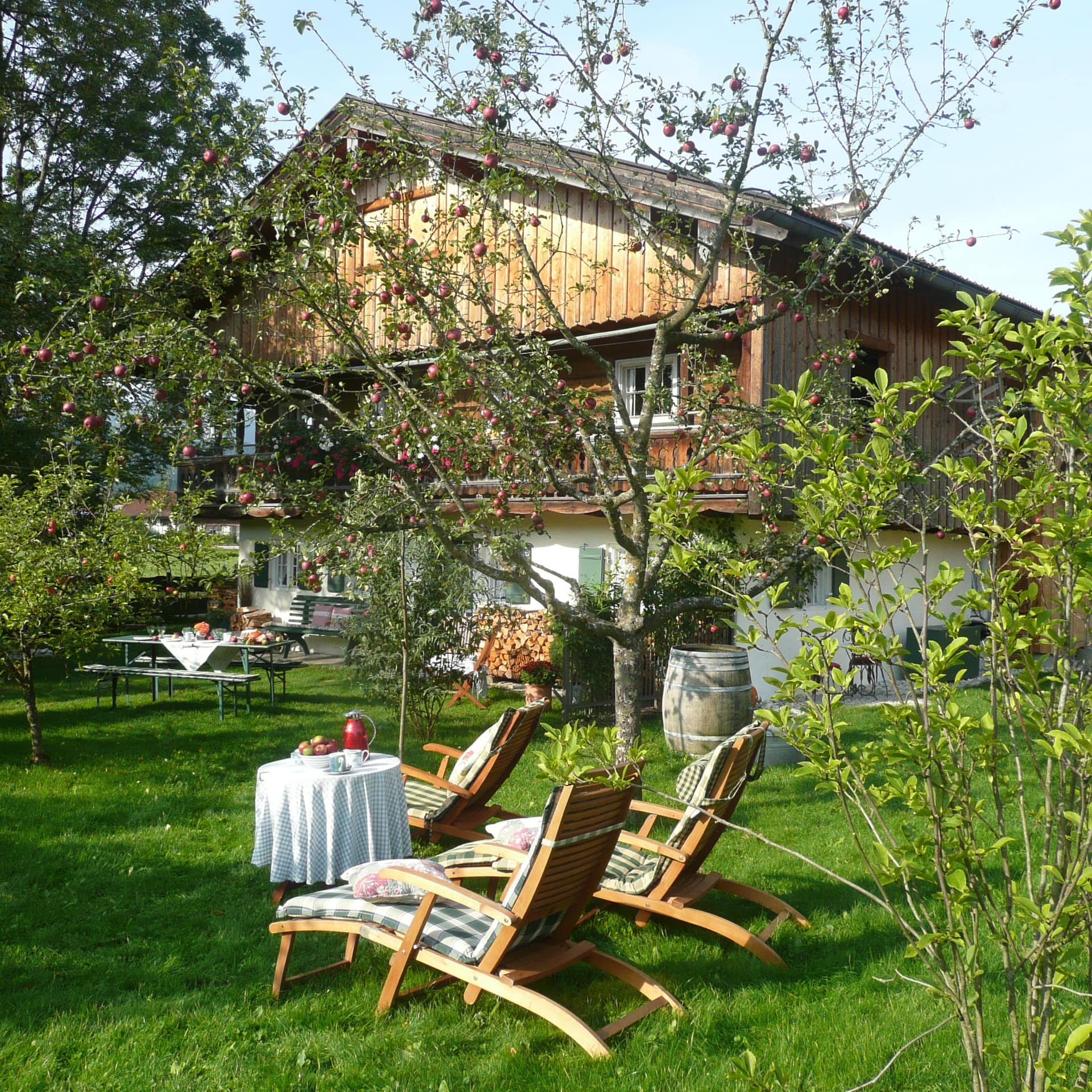 Garten mit Obstbäumen und Liegestühlen eines Bauernhauses am Tegernsee