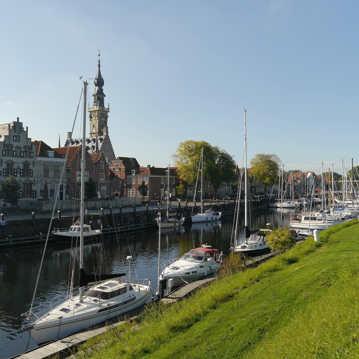 Häuser in Zeeland an einem Kanal in dem Boote ankern