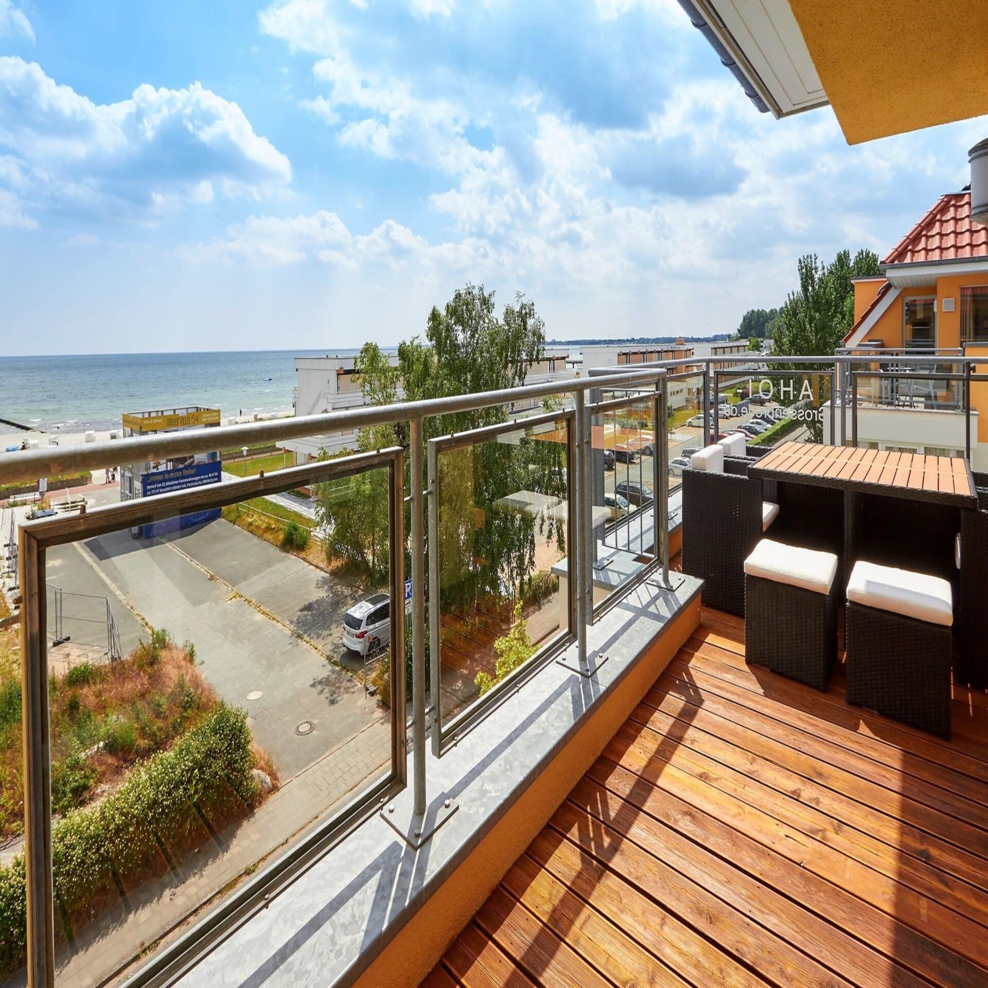 Balkon mit Glasbalustrade und Blick auf die Ostsee. Die Sonne scheint.