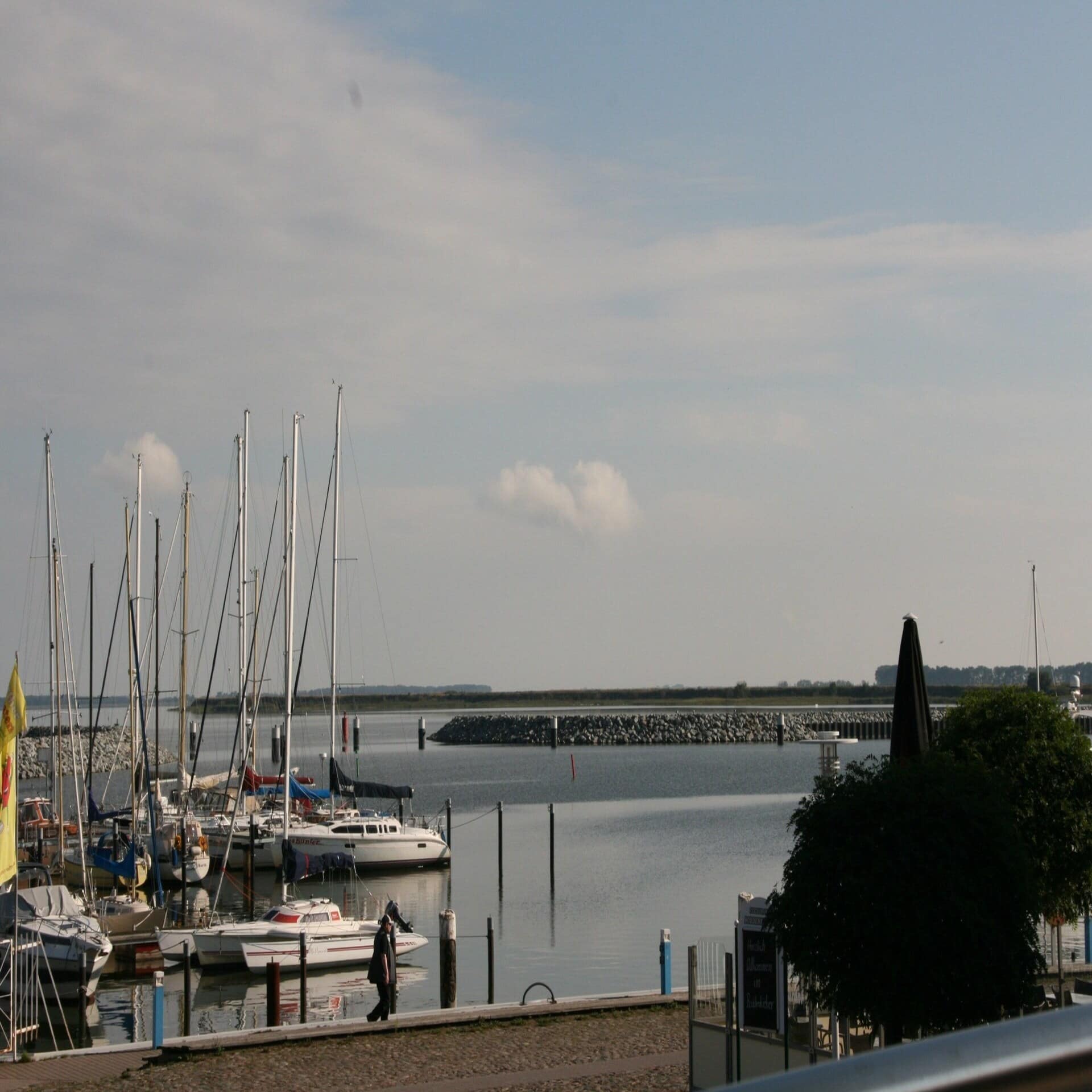 Blick vom Balkon auf den Bodden und kleine Boote vor Anker.