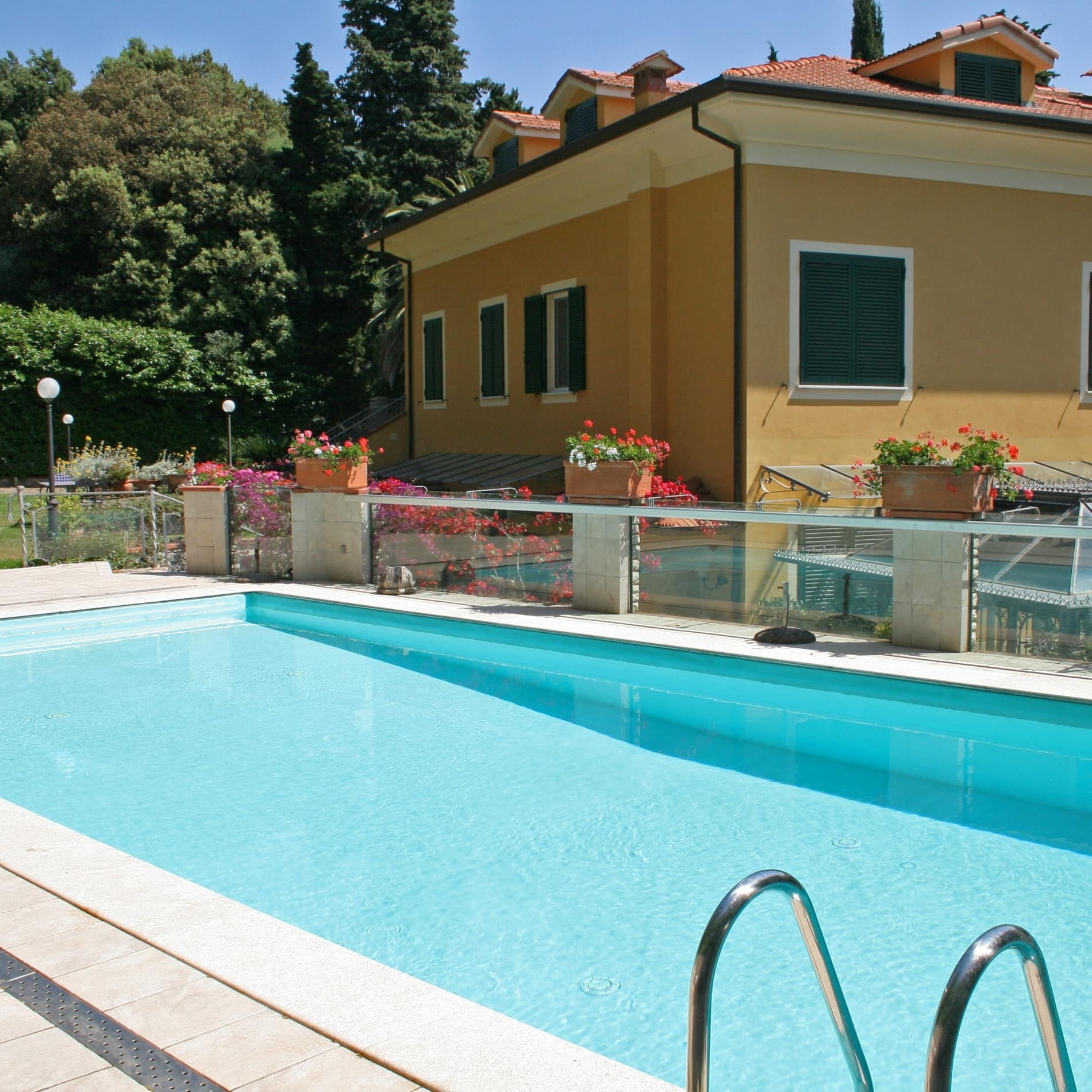 Das Blau des gepflegten Pools bildet einen Kontrast zum Ocker der Ferienwohnung in Lerici, Ligurien