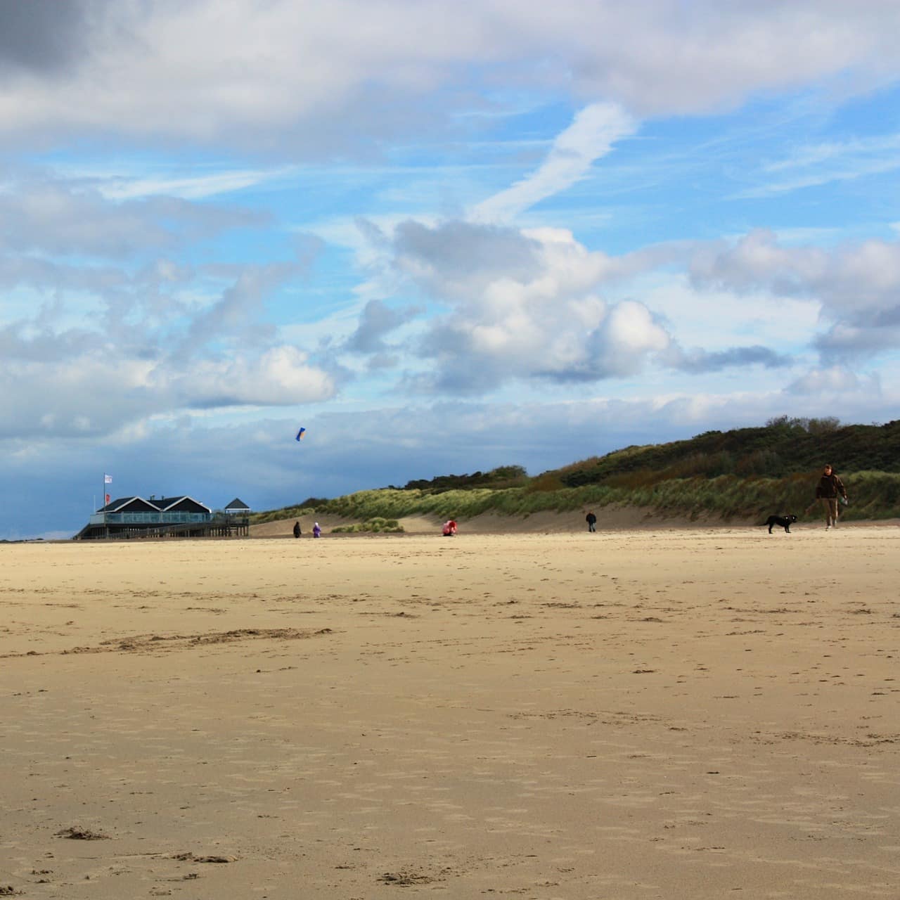 Blick über den Strand und die Dünenlandschaft und Häuser im Hintergrund