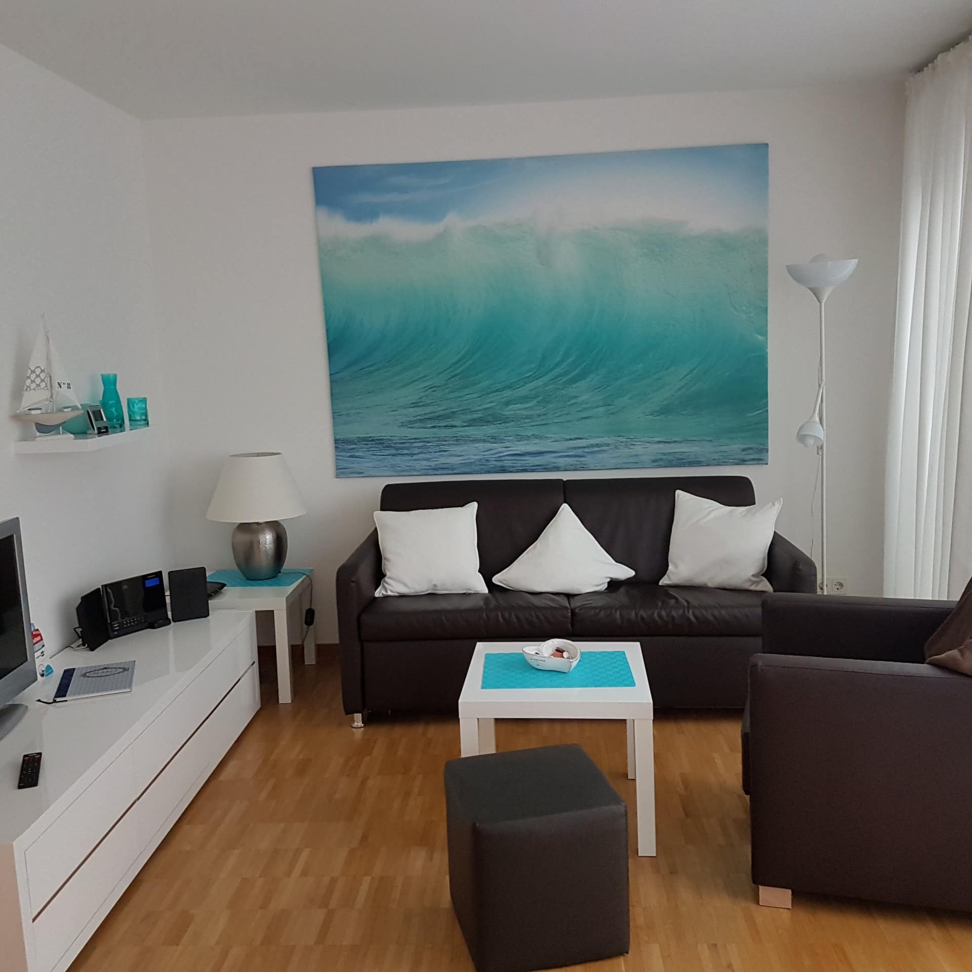 Wohnzimmer einer hell und maritim eingerichteten Ferienwohnung in Travemünde.