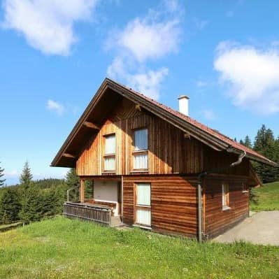 Ein Ferienhaus aus Holz in den Bergen in Österreich, von Bäumen umgeben